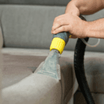 Curățare profesională canapea cu aparat de aspirat.